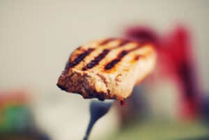 A juicy grilled steak on a fork.