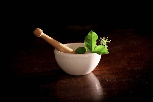 Herbs sitting inside a motar and pestle.