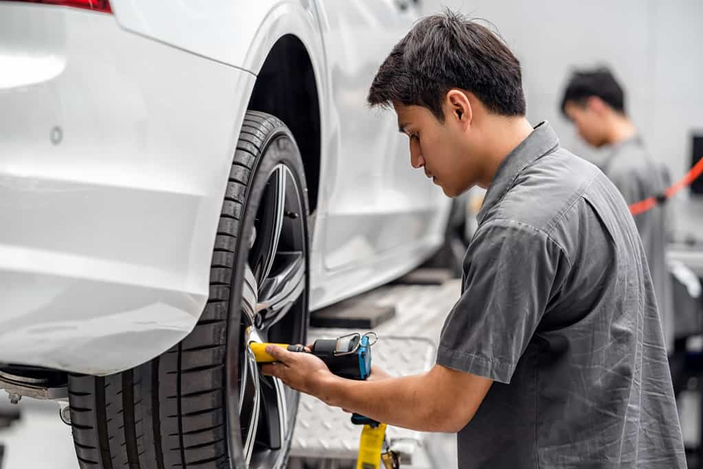 Asian mechanics checking the car wheels at maintainance service center for in showroom which is a part of showroom, technician or engineer professional work for customer, car repair concept